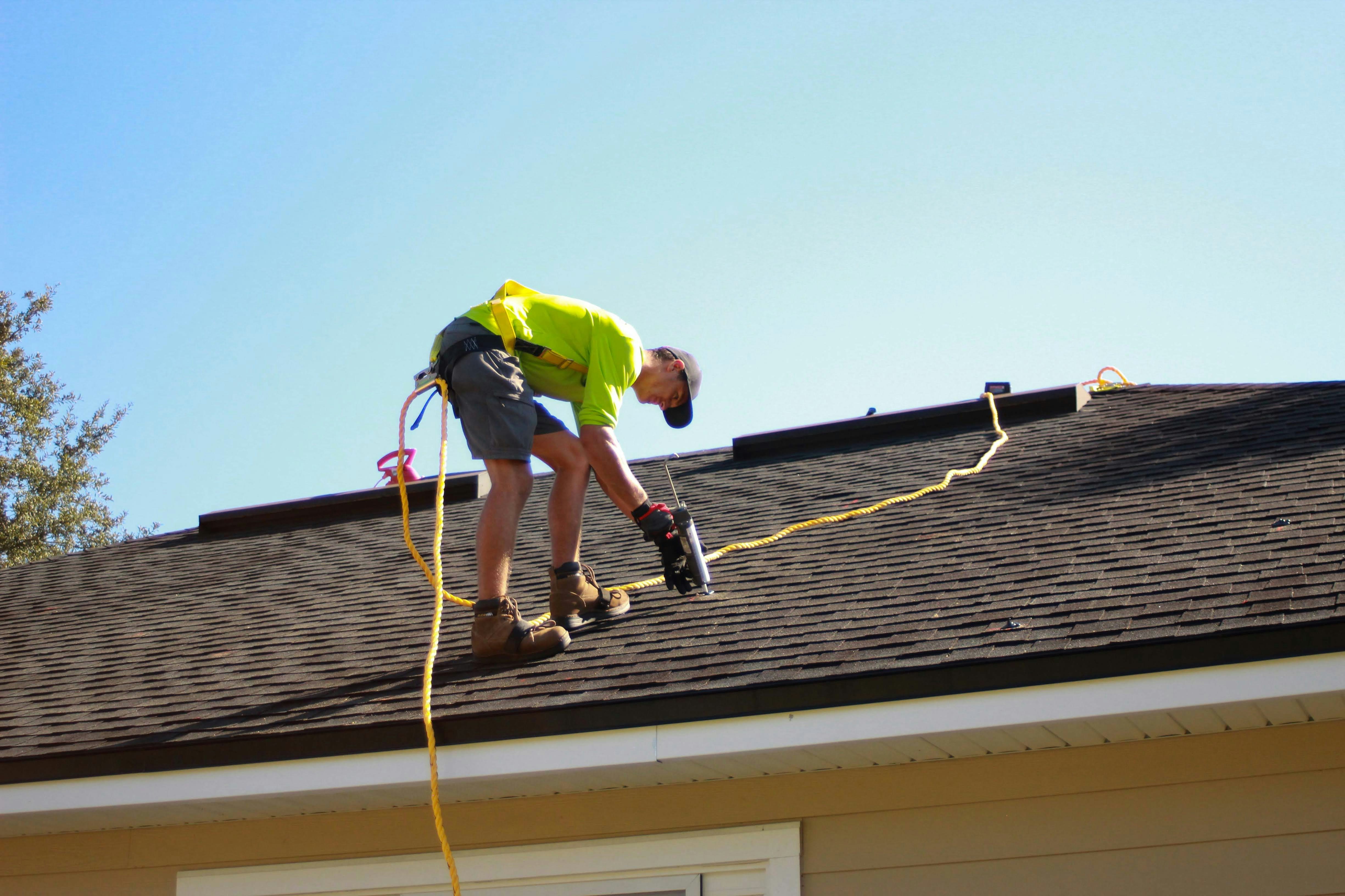 Roofer installing architectural shingles